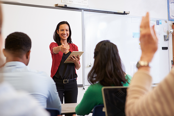 Smiling woman pointing to another person in a meeting