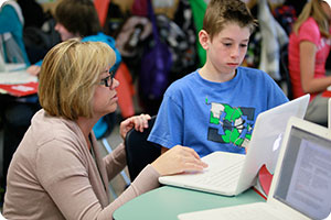 Student and teacher using laptop